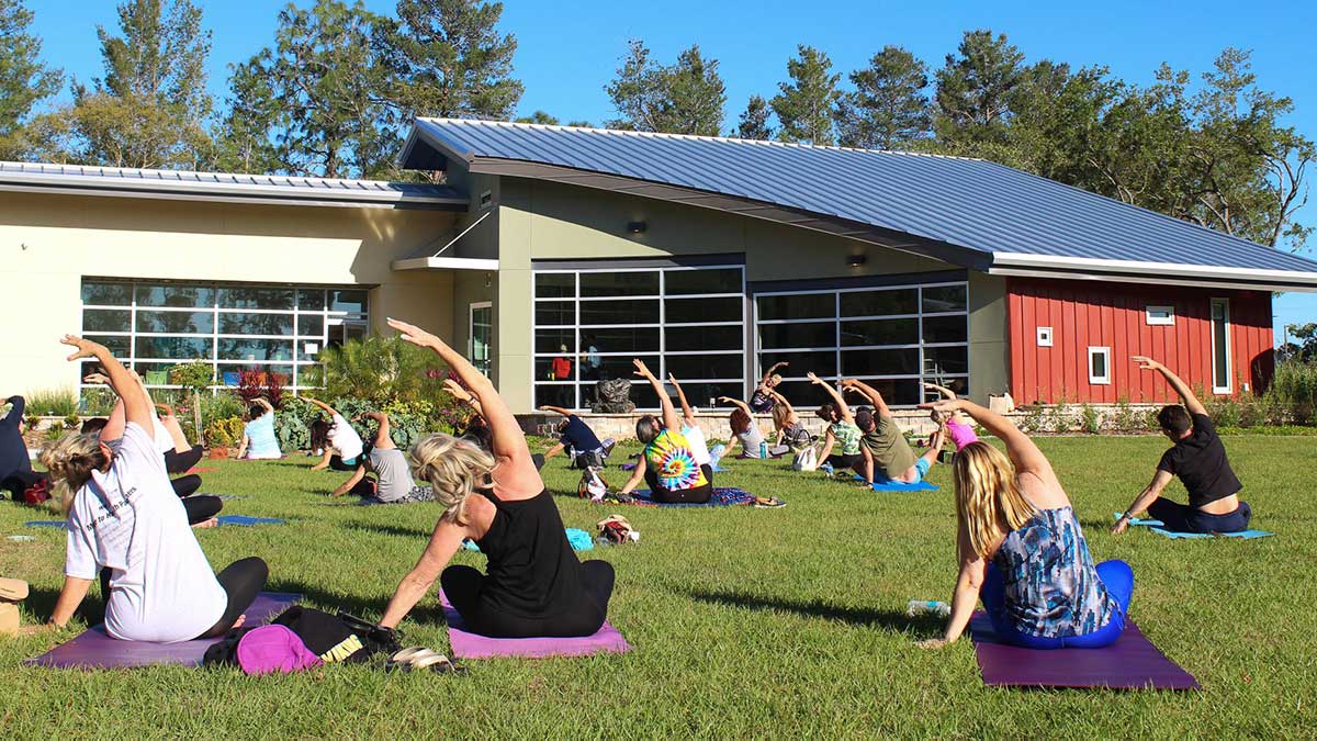 people doing yoga on the WellCome OM Center lawn