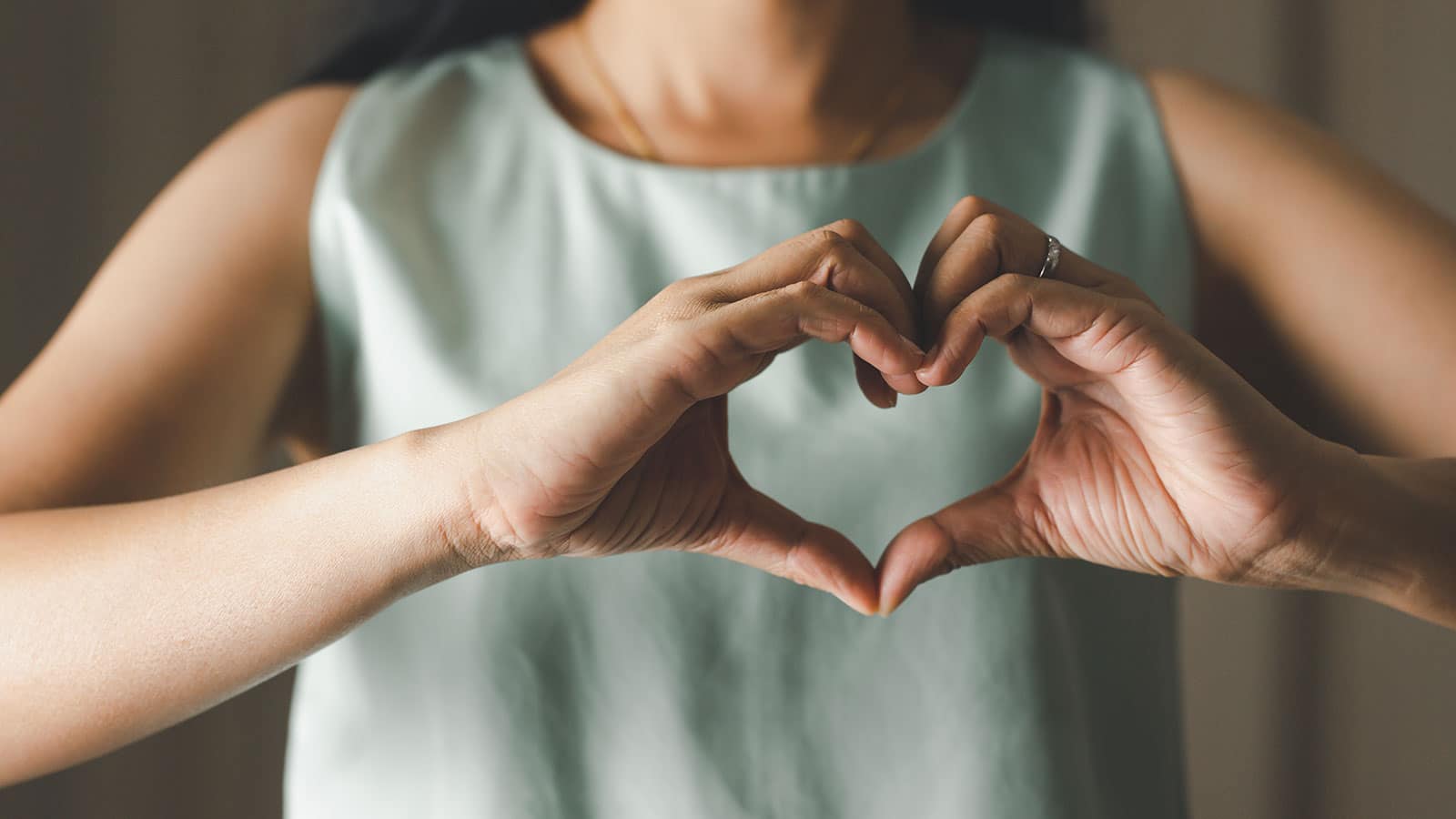 closeup of woman making heart shape with her hands